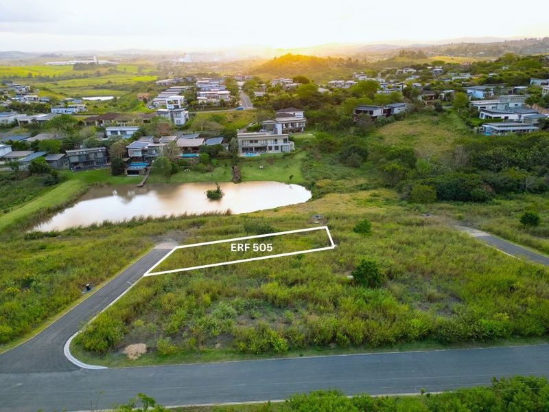 An aerial view of a vacant residential plot, Erf 505, featuring paved road access and scenic surroundings in a developed estate.