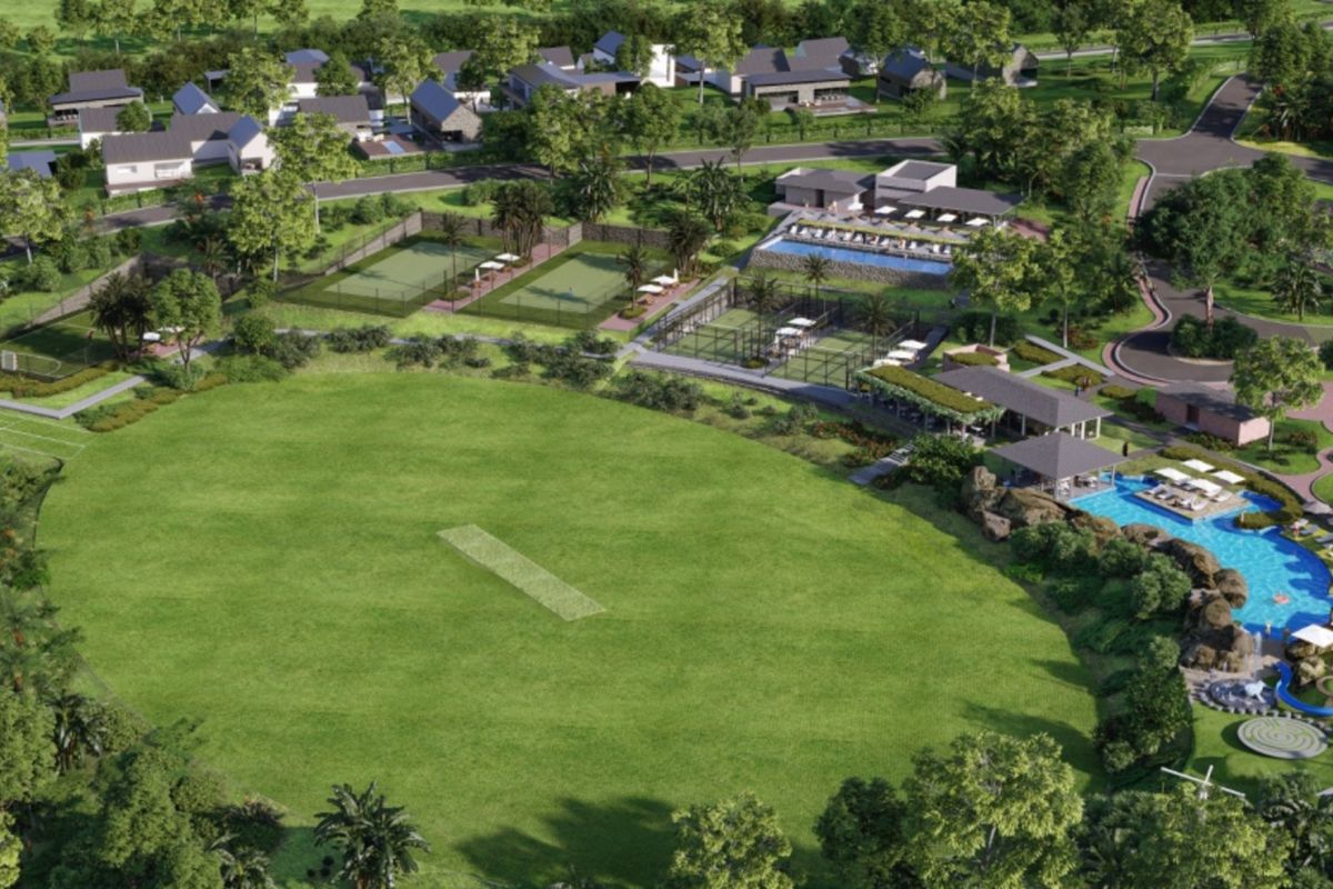 Aerial view of a residential estate featuring a cricket pitch, tennis courts, swimming pool, clubhouse, and landscaped communal areas.