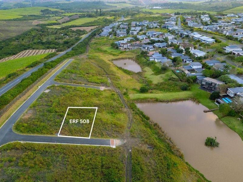 Aerial view of vacant residential plot ERF 508, situated in a developed estate with access to paved roads and nearby water features.