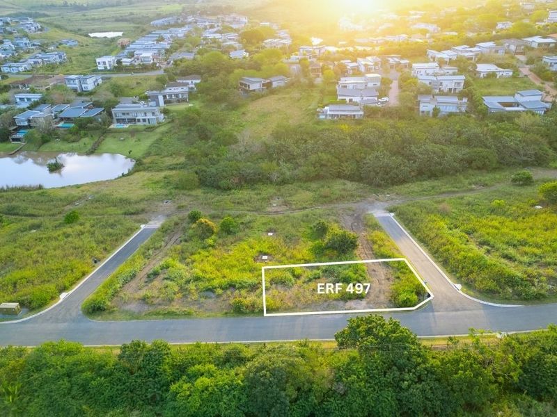 An aerial view of a vacant residential plot, Erf 497, situated within a developed estate with established road access and surrounding greenery.