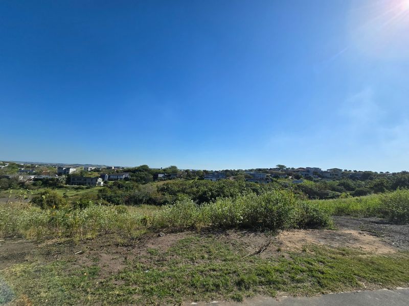 A wide-angle view overlooking a natural landscape with surrounding residential development in the distance.