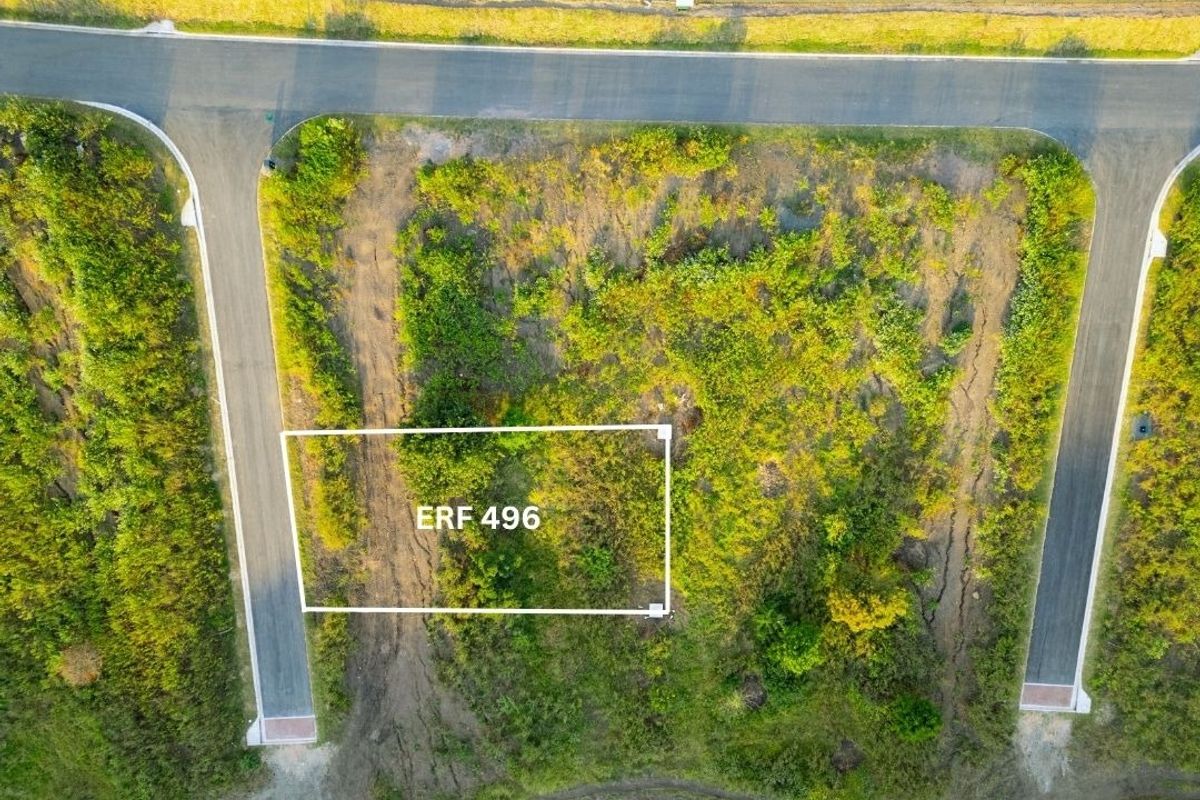 Aerial view of a vacant residential plot, Erf 496, featuring direct access to paved roads and surrounding natural vegetation.
