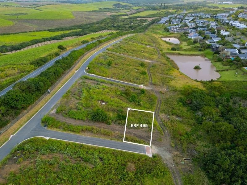 Aerial view of a vacant residential plot, Erf 495, featuring road access and surrounding landscape in a residential estate.
