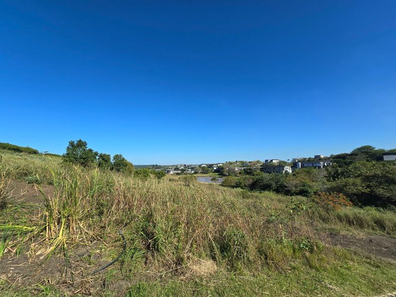 A wide-angle view of the vacant residential land, showcasing the natural landscape and surrounding estate scenery.