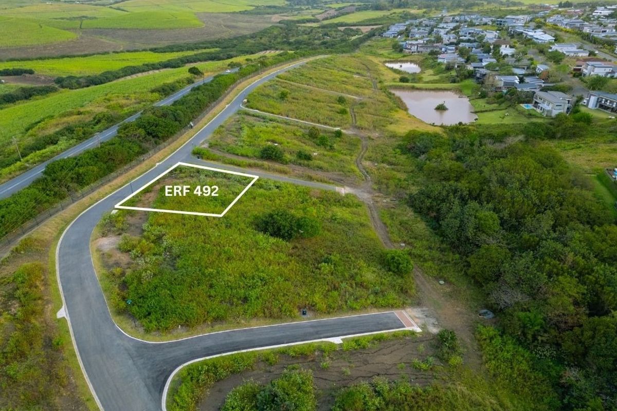 Aerial view of a vacant residential plot, ERF 492, situated in a developing estate with established road infrastructure and surrounding greenery.