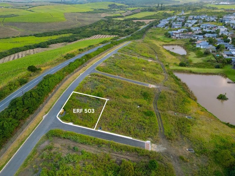 Aerial view of vacant residential Erf 503, featuring direct road access and proximity to local estate amenities and natural landscape.