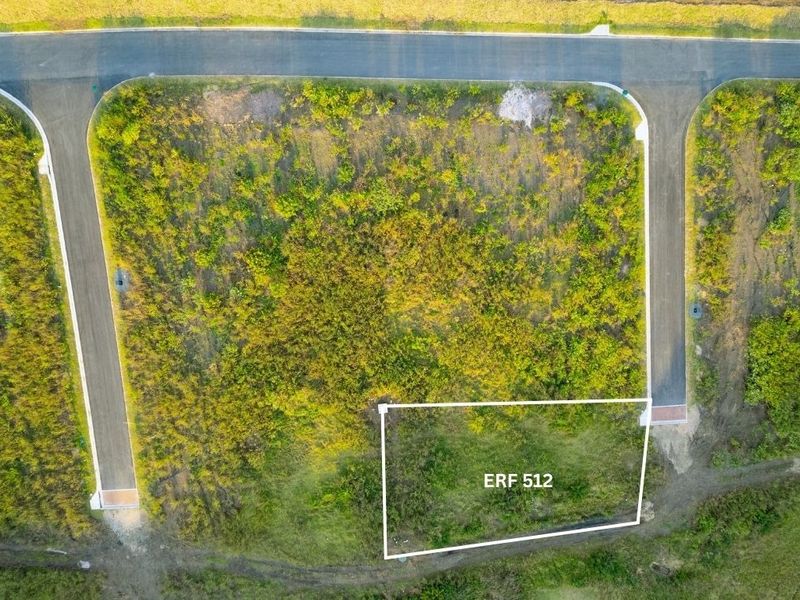 Aerial view of a vacant residential plot, identified as Erf 512, situated within a developed estate with established road access.