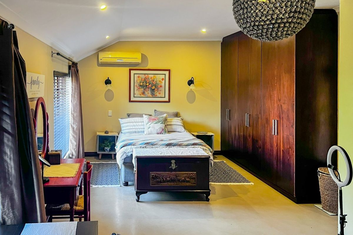Spacious bedroom featuring extensive dark wood built-in cabinetry, split-system air conditioning, and modern recessed lighting.