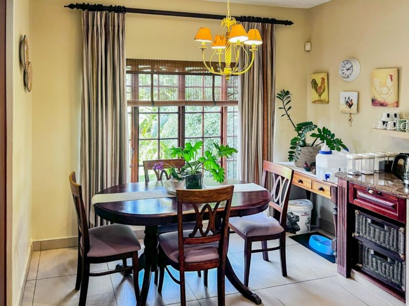A dining area featuring tiled flooring, a wooden window frame, and built-in cabinetry with a granite countertop.