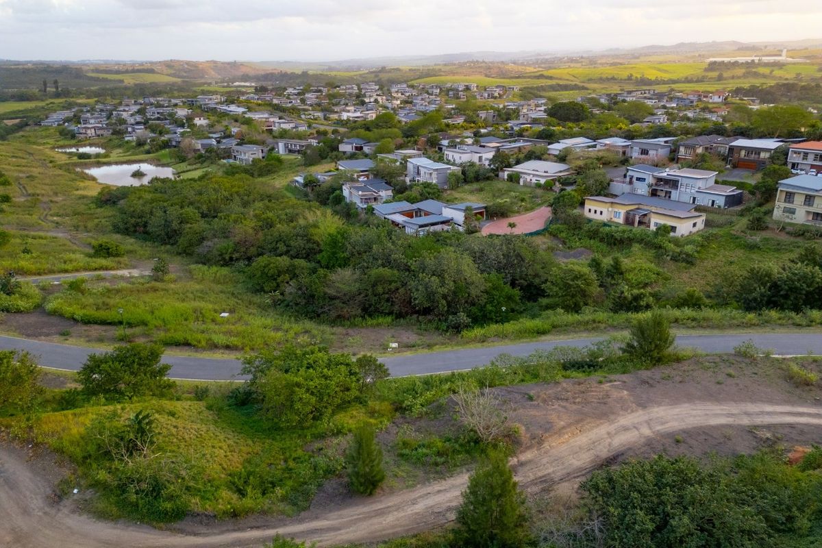 Aerial view of a residential estate featuring natural landscape, surrounding vegetation, and established road infrastructure.
