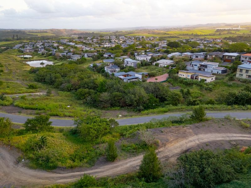 Aerial view of a residential estate featuring natural landscape, surrounding vegetation, and established road infrastructure.