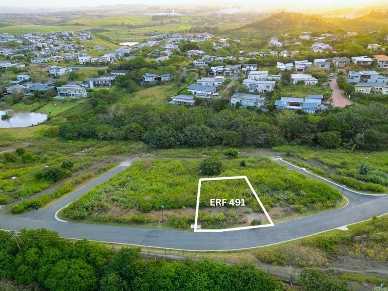 An aerial view of a vacant residential plot, identified as Erf 491, situated within a developed estate with established road access and surrounding greenery.