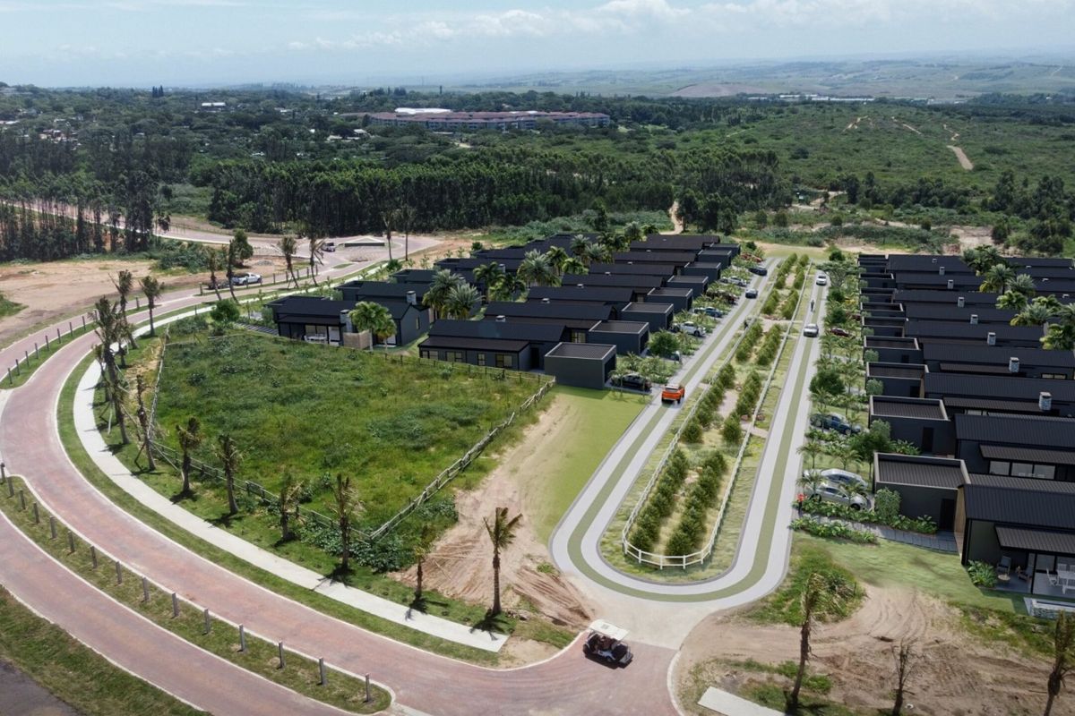 Aerial view of a modern residential housing development featuring uniform dark-roofed homes, paved access roads, and landscaped surroundings within a gated estate.
