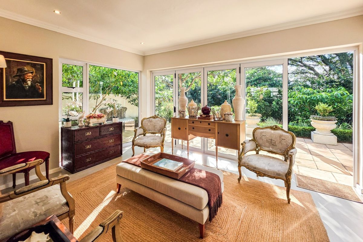 Bright living room featuring tiled flooring, recessed lighting, and large aluminium folding doors providing seamless access to the outdoor patio and garden.