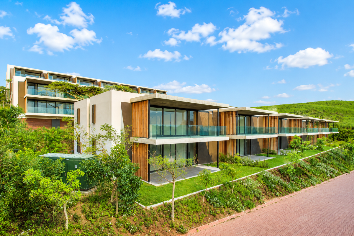 Modern apartment complex featuring contemporary architecture with timber cladding, glass balustrades, and private balconies overlooking landscaped grounds.