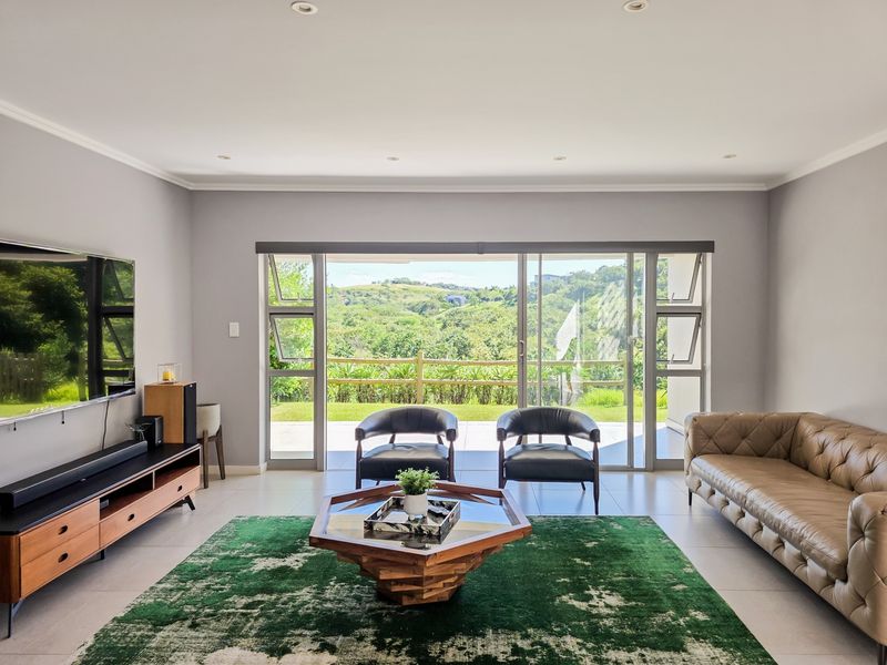 Spacious living room featuring large sliding glass doors that provide natural light and direct access to the outdoor area with scenic views.