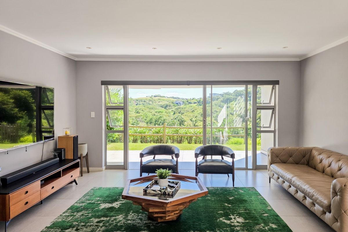 Spacious living room featuring large sliding glass doors that provide natural light and direct access to the outdoor area with scenic views.
