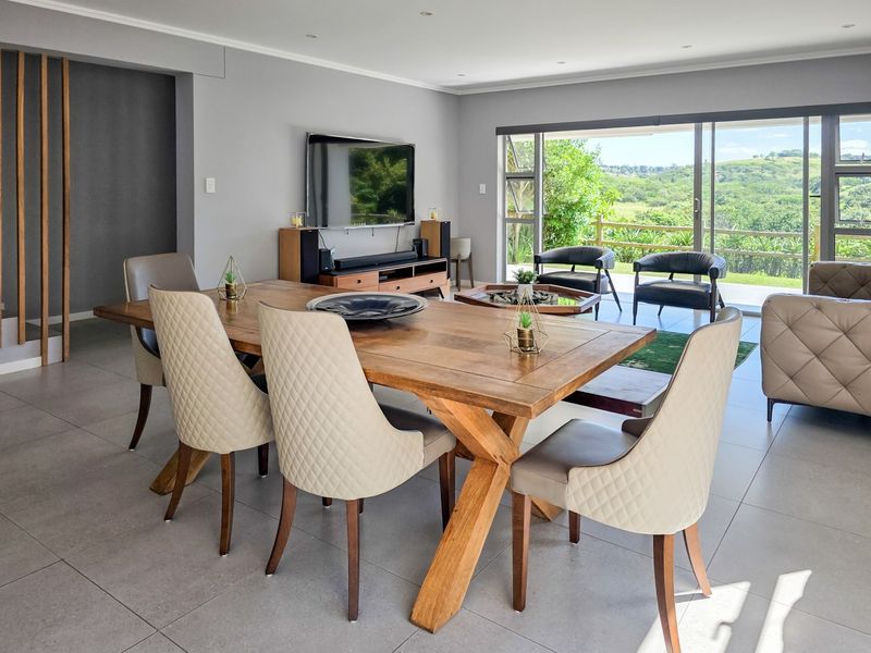 Spacious open-plan living and dining area featuring large sliding glass doors that provide natural light and access to the outdoor view.