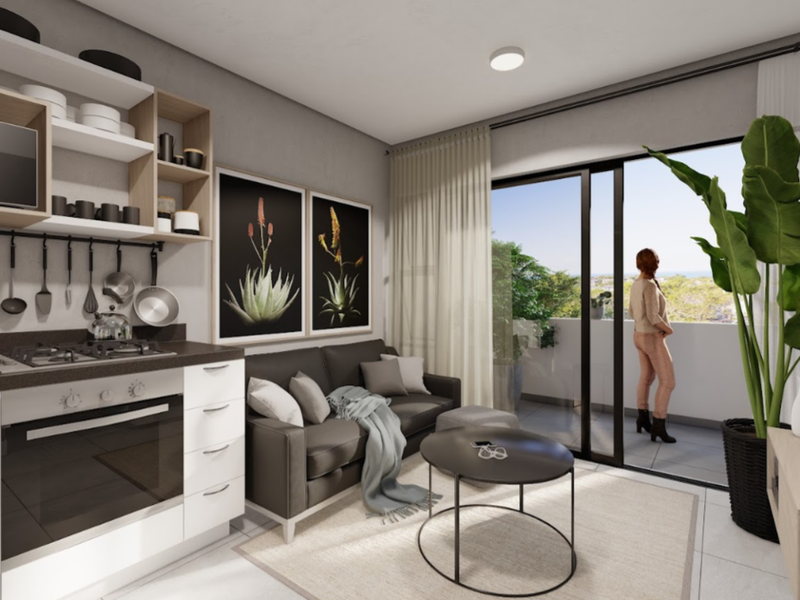 Modern open-plan apartment living area featuring a compact kitchen with built-in appliances and seamless access to a private balcony.