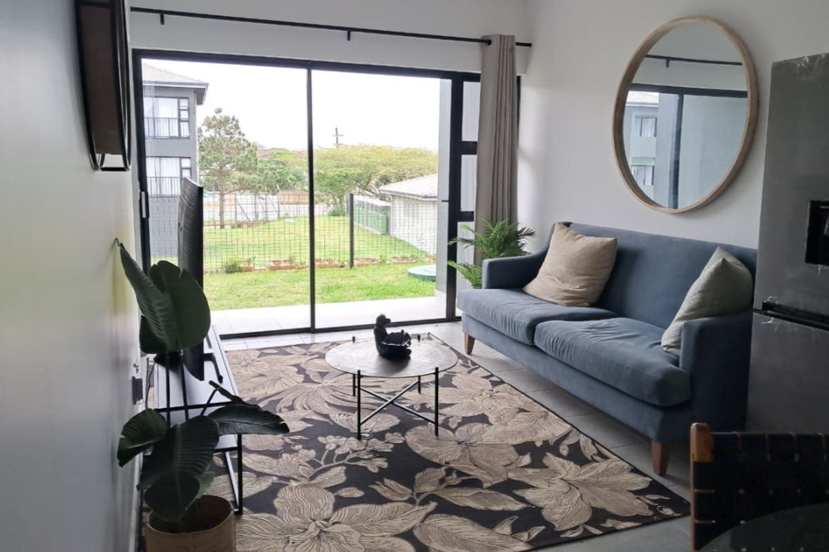 A bright living room featuring large sliding glass doors that provide access to the outdoor area and allow for ample natural light.