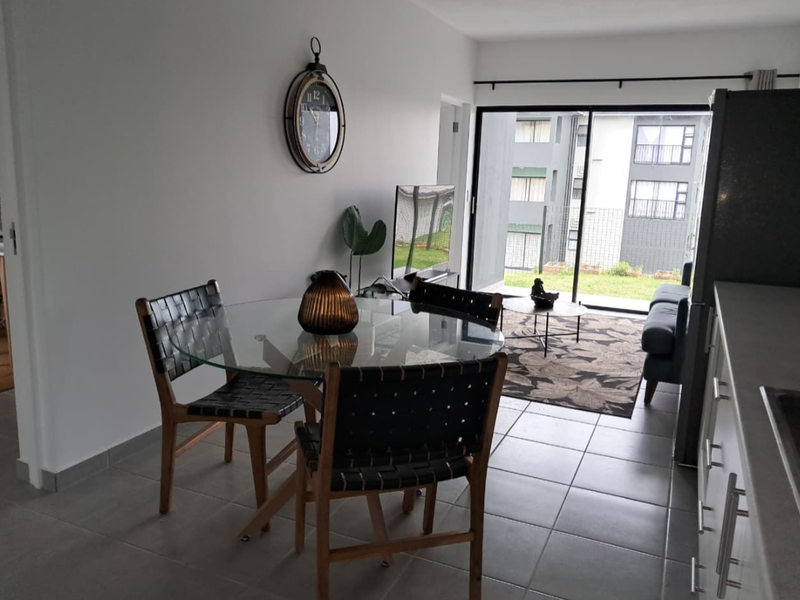 Open plan living and dining area featuring tiled flooring and a large sliding glass door leading to an outdoor patio space.