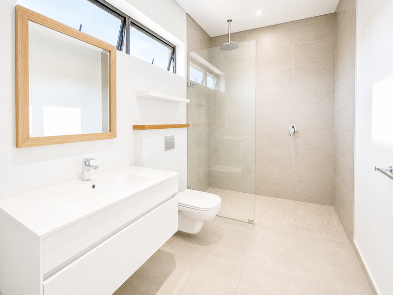 Modern bathroom featuring a wall-mounted vanity, wall-hung toilet with concealed cistern, and a spacious walk-in shower with a rainfall shower head and glass screen.
