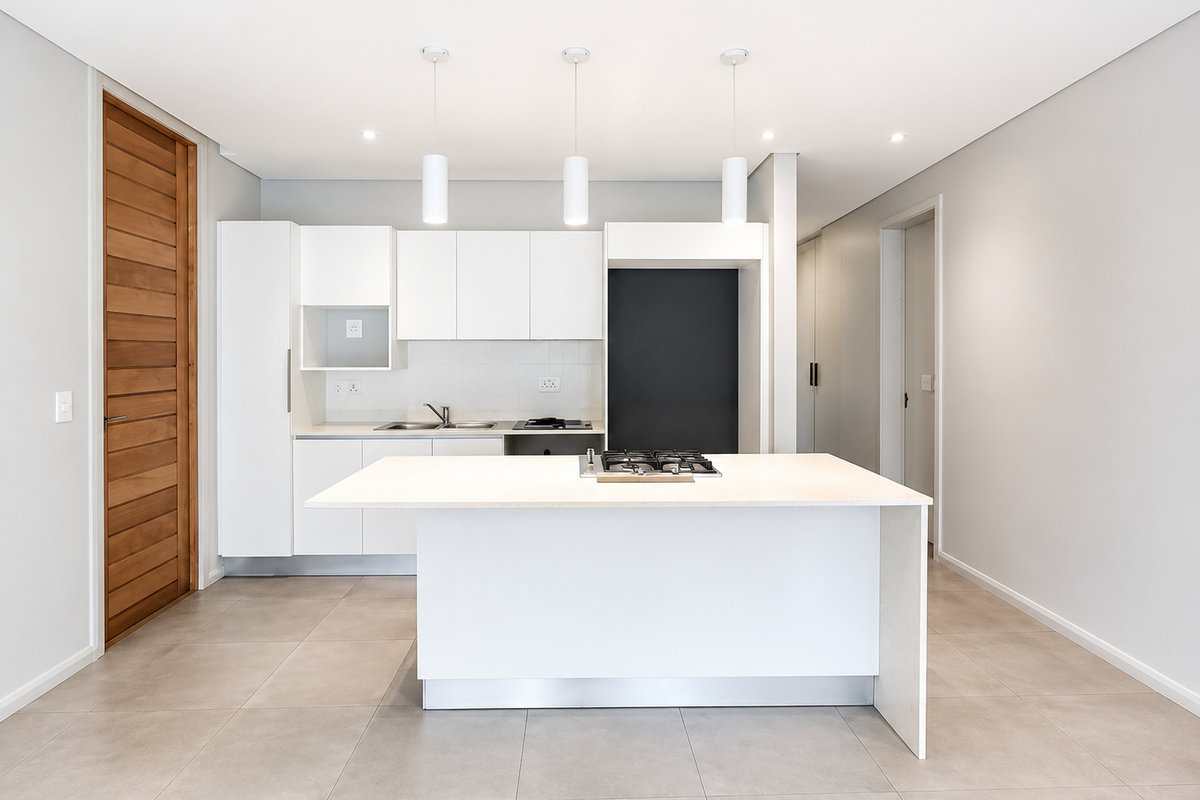 Modern kitchen featuring a central island with a gas cooktop, sleek white cabinetry, tiled flooring, and contemporary pendant lighting in an open-plan layout.