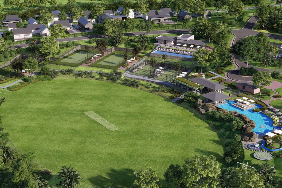 Aerial view of a residential estate featuring a cricket pitch, tennis courts, swimming pool, and clubhouse facilities within a landscaped community setting.