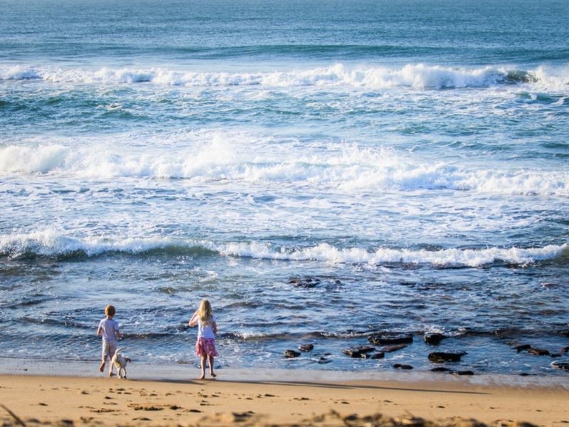 A scenic view of the ocean coastline, highlighting the natural landscape and beach access associated with the property location.