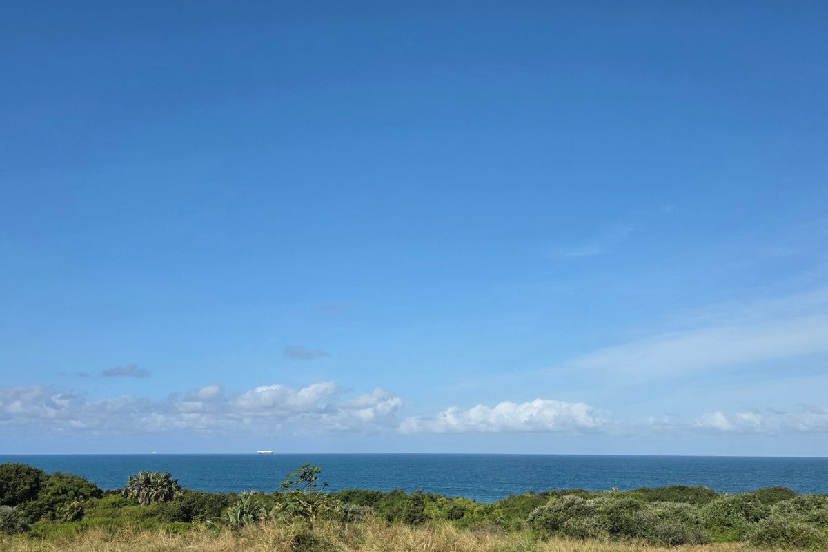 A scenic, elevated view of the ocean horizon and coastal vegetation, showcasing the natural landscape of the vacant residential property.