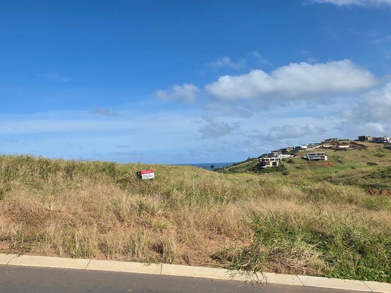 A vacant residential plot featuring a gentle slope and road frontage, offering potential for development with scenic coastal views in the surrounding area.