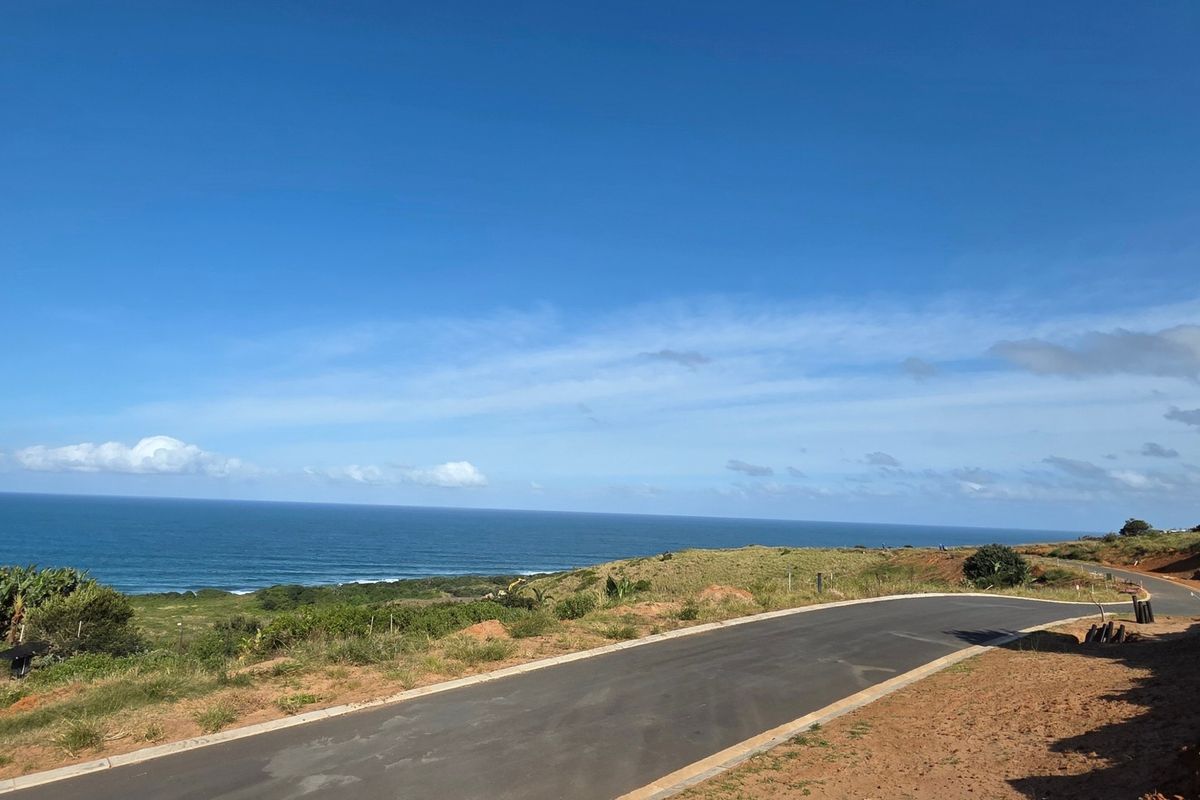 A scenic view of the coastline featuring a paved access road leading through the vacant residential land.