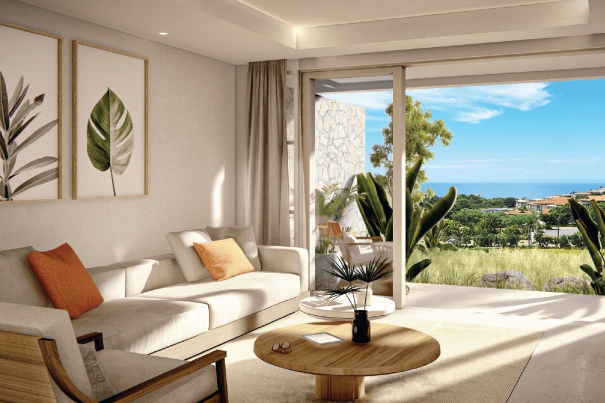 Modern living room featuring recessed lighting and large sliding glass doors that open to a scenic balcony with ocean views.