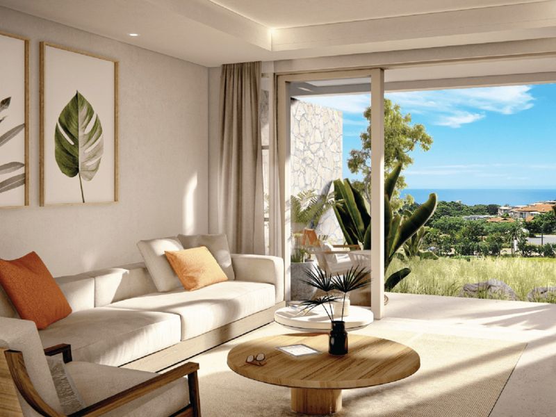 Modern living room featuring recessed lighting and large sliding glass doors that open to a scenic balcony with ocean views.