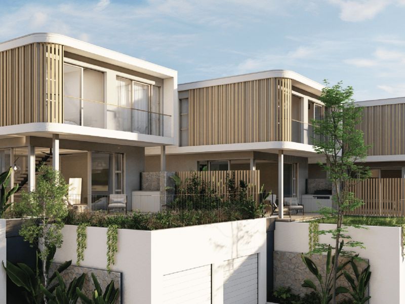Modern townhouse development featuring timber batten cladding, glass balustrades, and stone masonry accents with integrated garage access and private patio spaces.