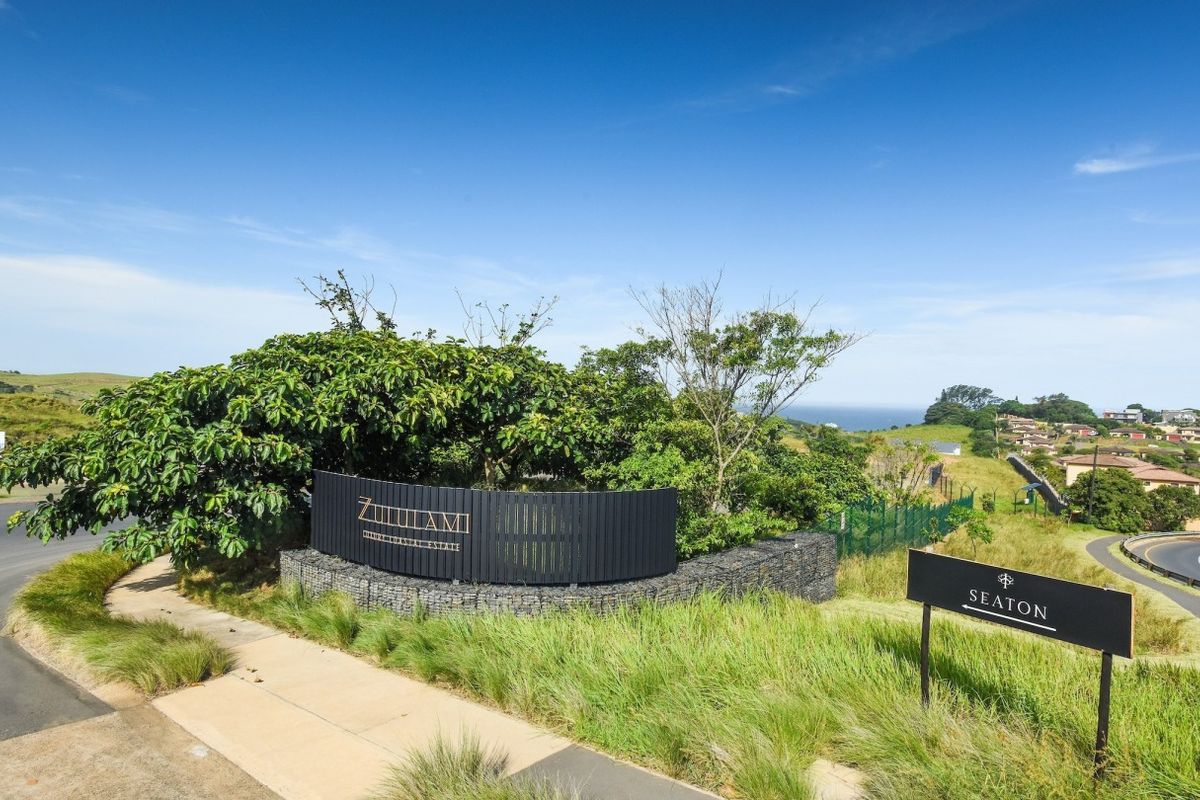 Entrance view of Zululami Luxury Coastal Estate featuring professional landscaping, gabion walling, and clear directional signage.