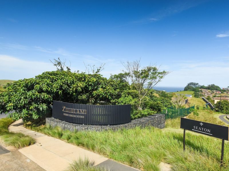 Entrance view of Zululami Luxury Coastal Estate featuring professional landscaping, gabion walling, and clear directional signage.