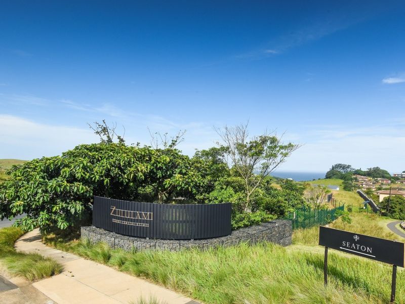 A well-maintained entrance area for Zululami Coastal Estate, featuring modern gabion walling, professional signage, and landscaped surroundings with coastal views.