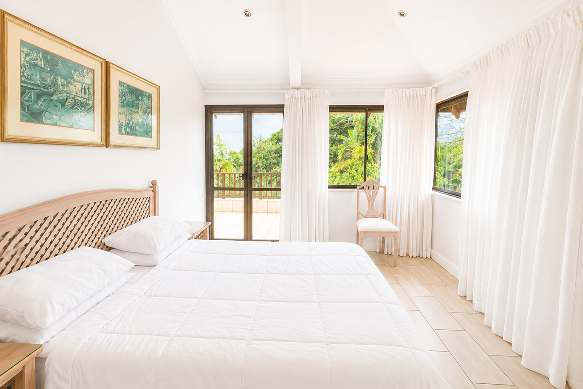 Bright and airy bedroom featuring vaulted ceilings, tiled flooring, and direct access to an outdoor balcony through sliding glass doors.