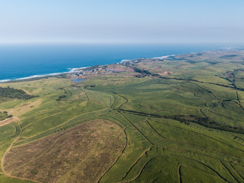 An expansive aerial view of the coastal farm property, showcasing vast agricultural fields and proximity to the ocean.