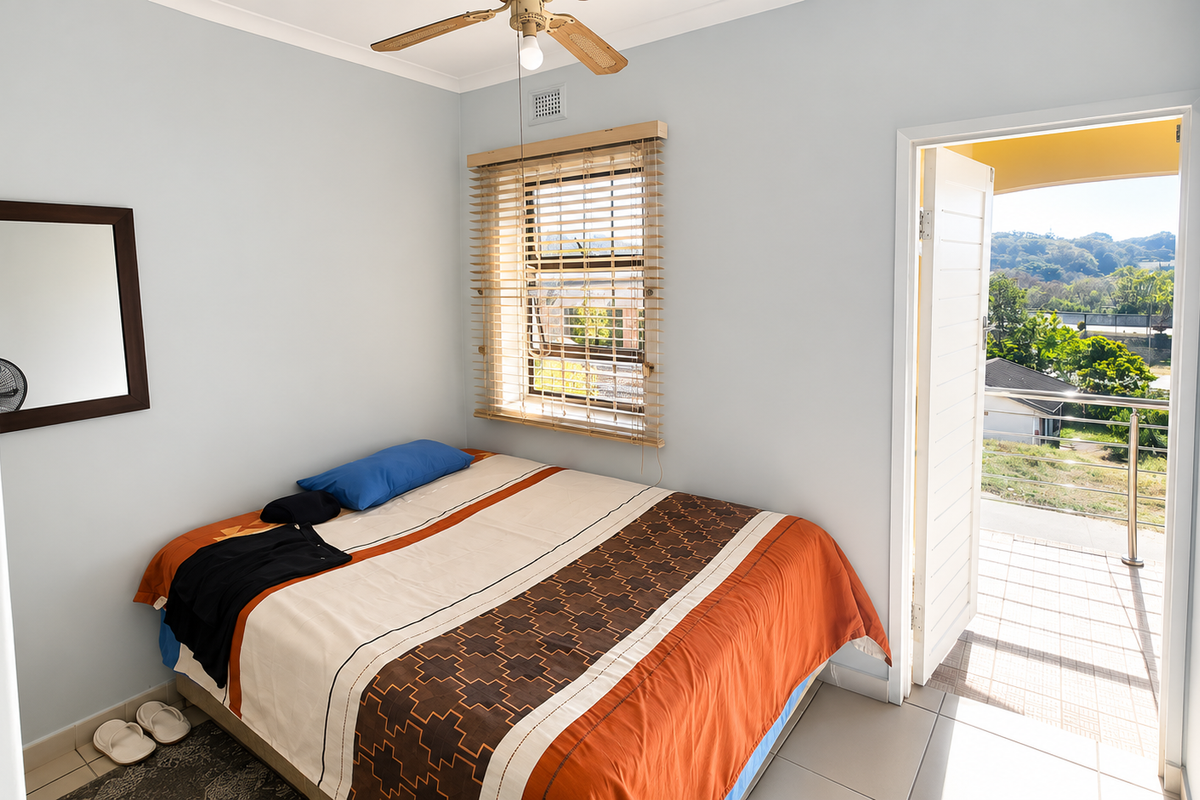 A bedroom featuring tiled flooring, a ceiling fan, and direct access to an outdoor balcony through a glass-panelled door.