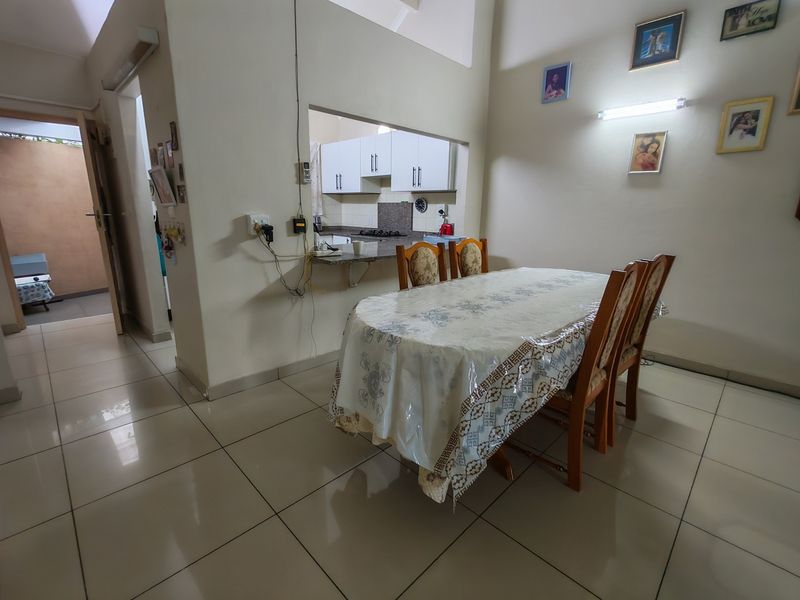 Open plan dining area featuring tiled flooring and a convenient pass-through window connecting to the kitchen space.