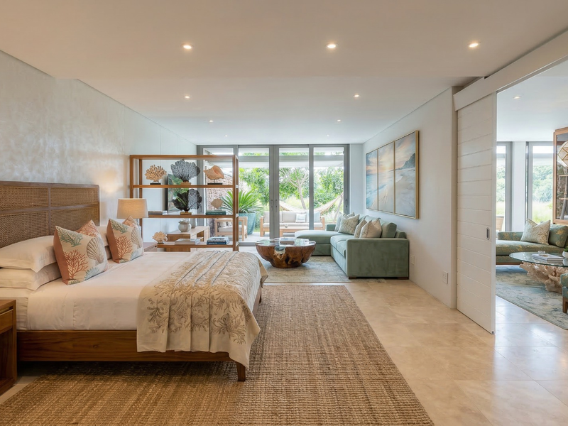 Spacious master bedroom featuring stone flooring, recessed lighting, and large glass sliding doors leading to an outdoor patio area.
