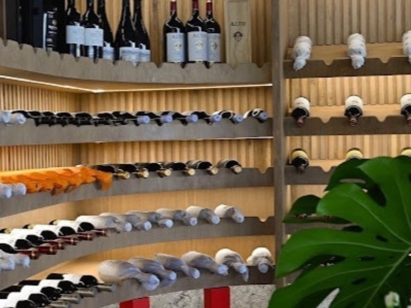 A sophisticated custom wine cellar featuring bespoke timber racking, integrated LED accent lighting, and elegant slatted wall paneling for optimal bottle display.