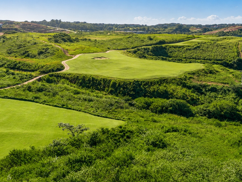 An elevated aerial view showcasing the expansive green fairways and natural landscape surrounding the property estate.