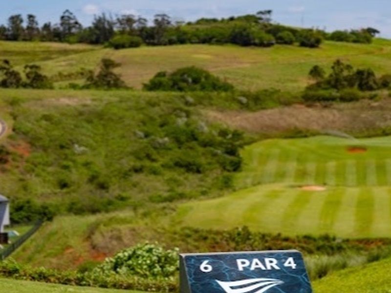 A scenic view overlooking a manicured golf course fairway and rolling green hills within a residential estate setting.