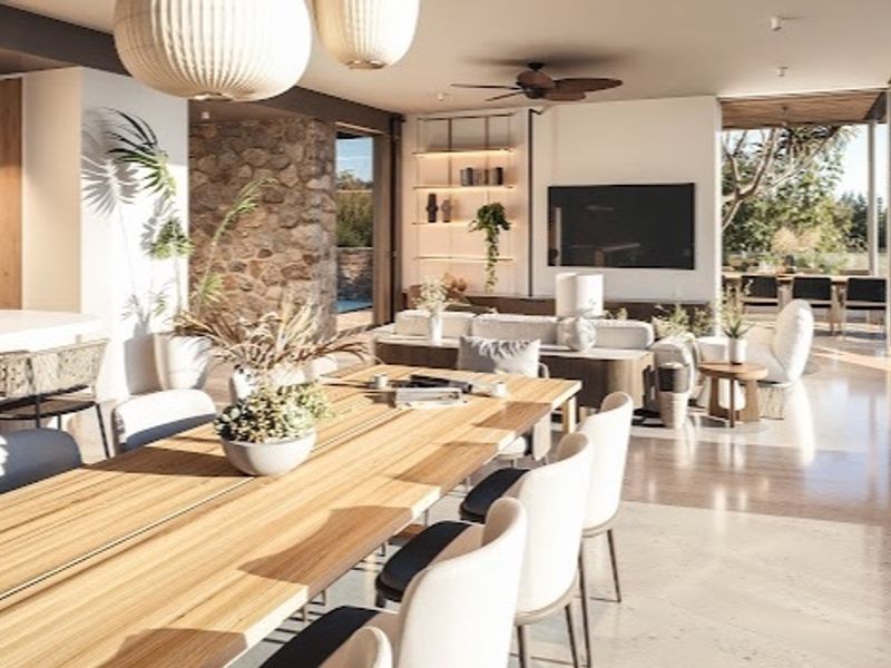 Spacious open-plan living and dining area featuring a stone accent wall, polished concrete floors, and seamless transition to an outdoor patio.