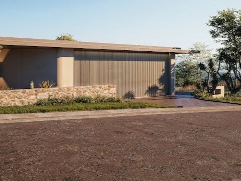 Modern residential exterior featuring stone cladding, a sleek garage door, and a paved driveway set within a landscaped environment.