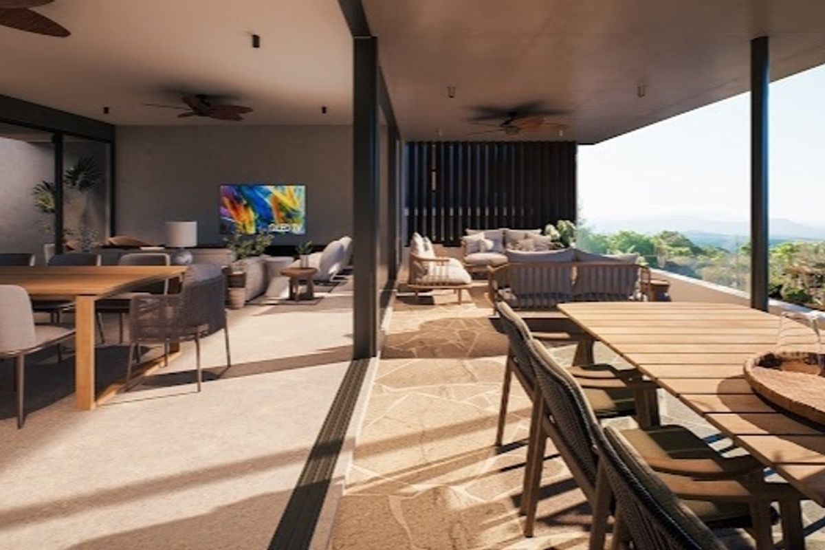 A spacious covered patio featuring stone flooring, recessed lighting, and ceiling fans, seamlessly connecting to the interior living area with expansive views.