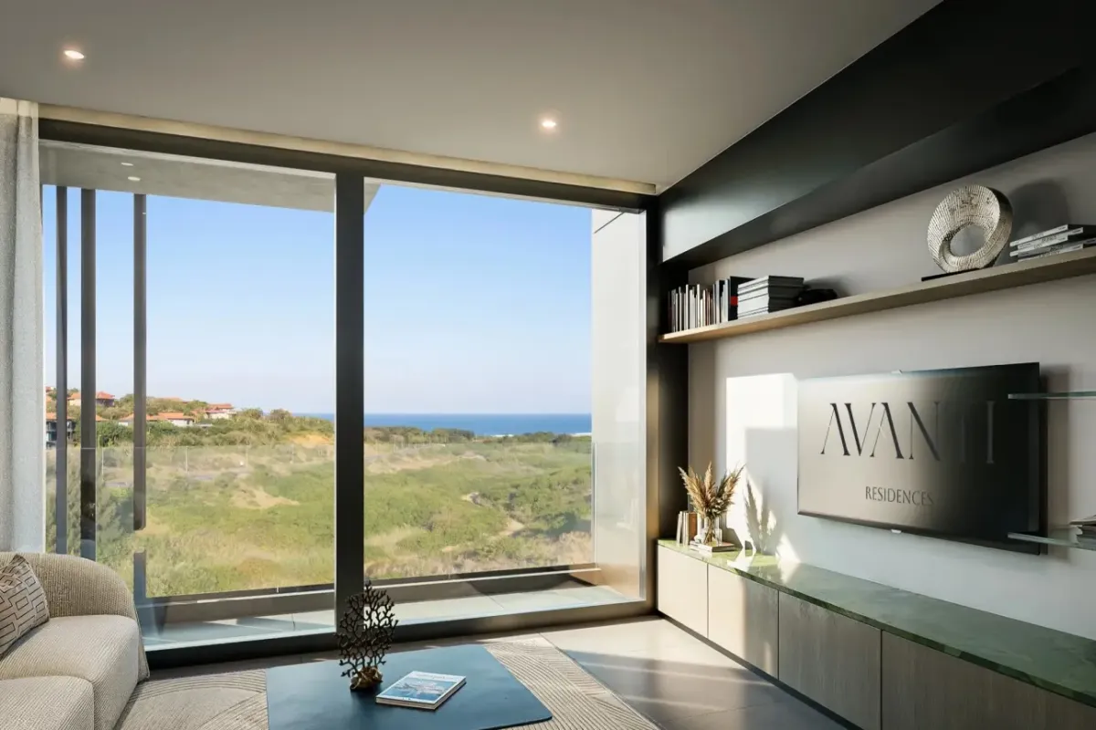 Modern living room featuring floor-to-ceiling windows with scenic coastal views, custom built-in cabinetry, and sleek recessed lighting.